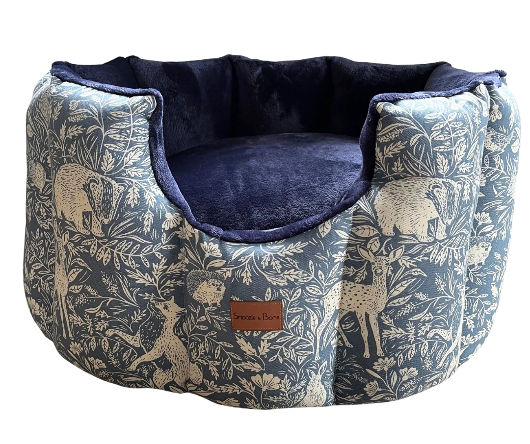 Dog bed with nature-themed fabric and navy interior on a white background