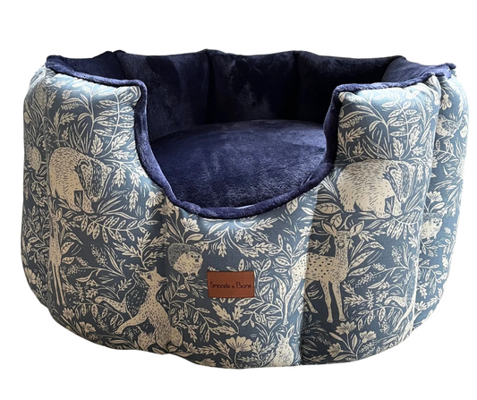 Dog bed with nature-themed fabric and navy interior on a white background